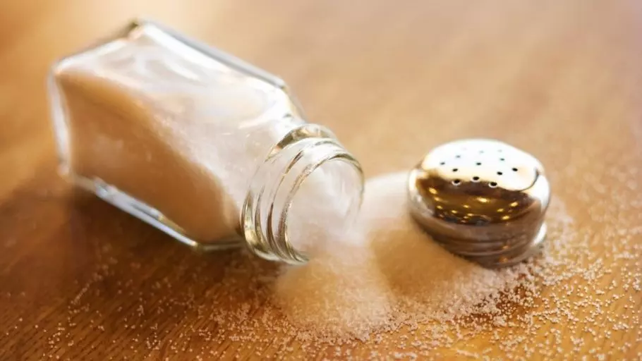 Раскрытая солонка на столе и просыпавшаяся соль