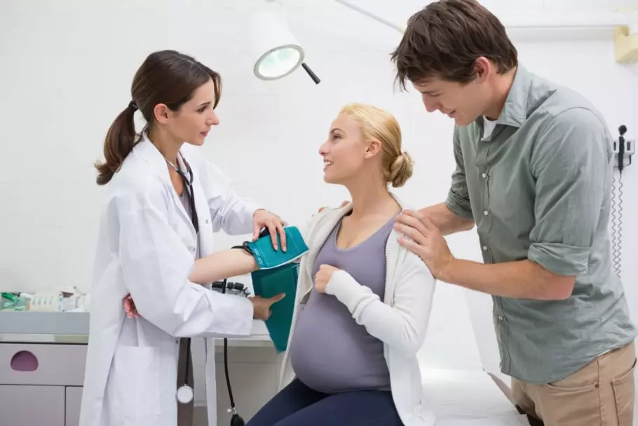Доктор готовится мерять давление беременной девушке